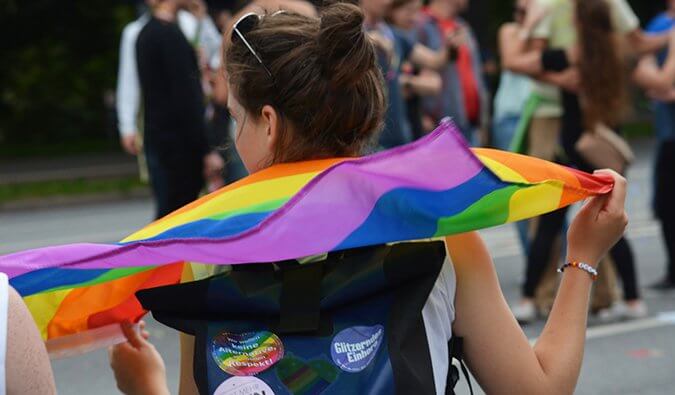 Lesbian holding a gay pride flag at a pride rally
