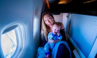 Blogger Kristin Addis traveling in an airplane with her young baby