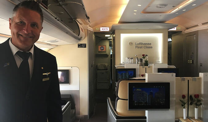cabin crew in the business class section of an airplane