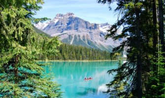 People canoeing on the bright, clear waters of Lake Louise, Alberta, Canada