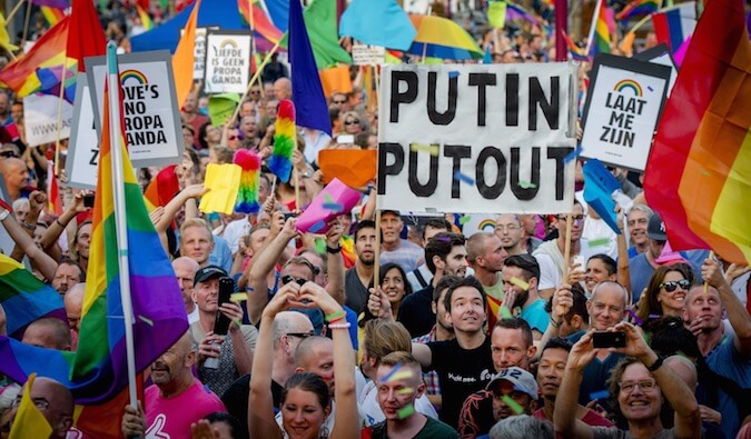 People holding up signs in a LGBT rights protest in Russia
