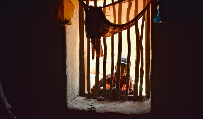 A young boy looking through a window in Madagascar