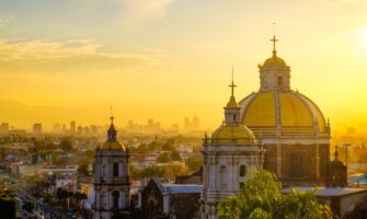 A golden sky over the sprawling Mexico City skyline in Mexico