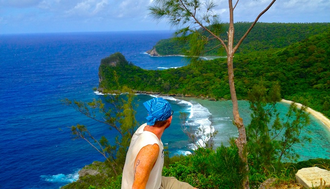Michael looking at beautiful beach surrounded by lush jungle