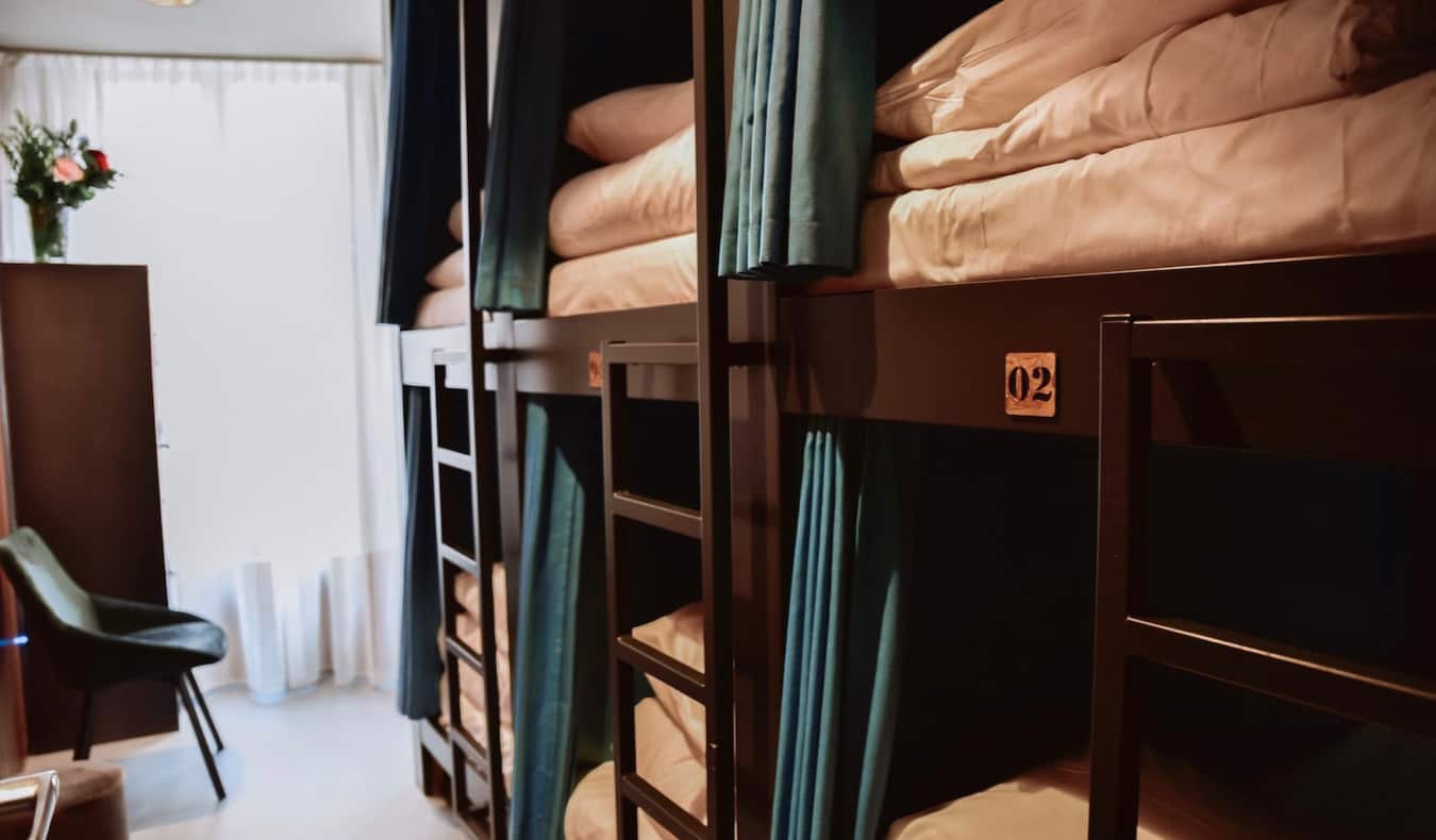 Closeup on dark wooden bunk beds with privacy curtains at Durty Nellys Inn
