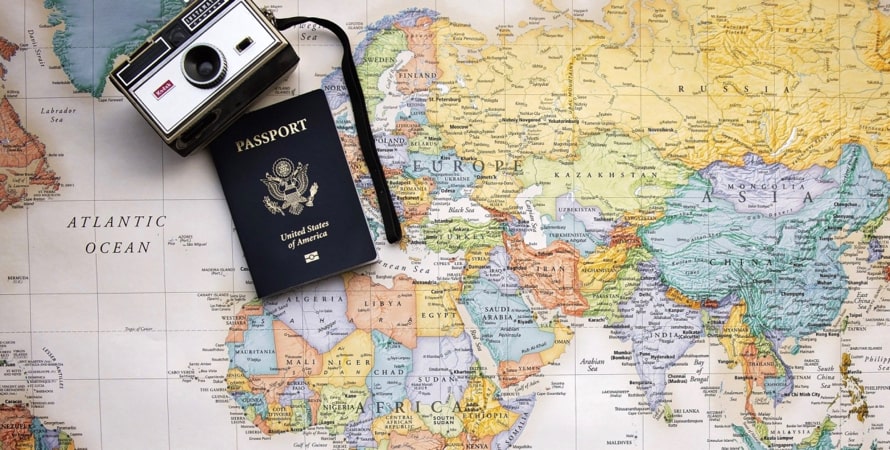 A map of the world with a camera and passport resting on it