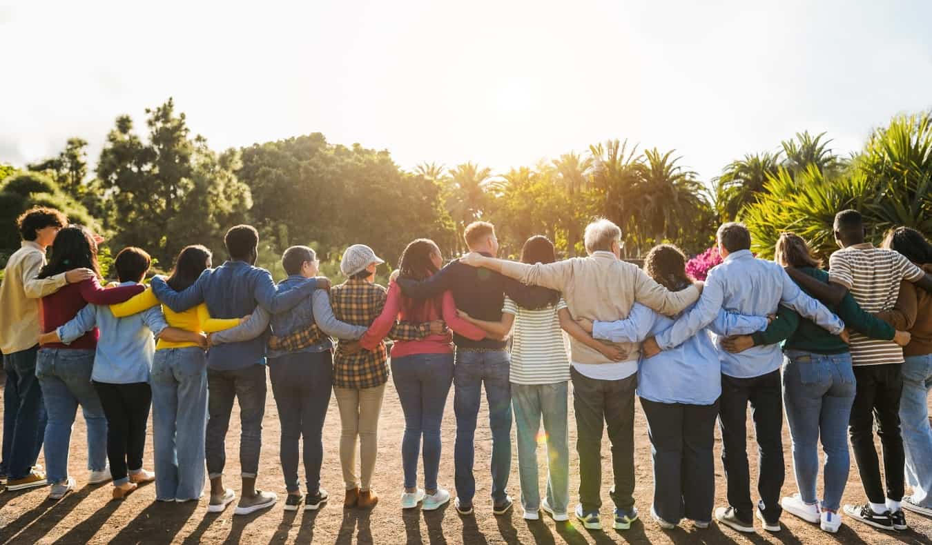 A group of of people stand in a circle hugging