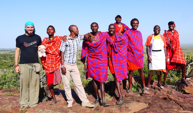 A traveler posing with the Massai people in Kenya